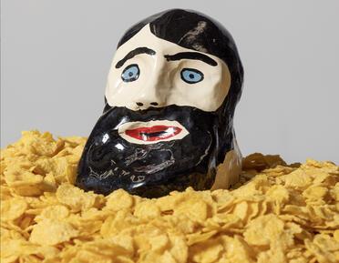 Sculpture of a head on a pile of cornflakes