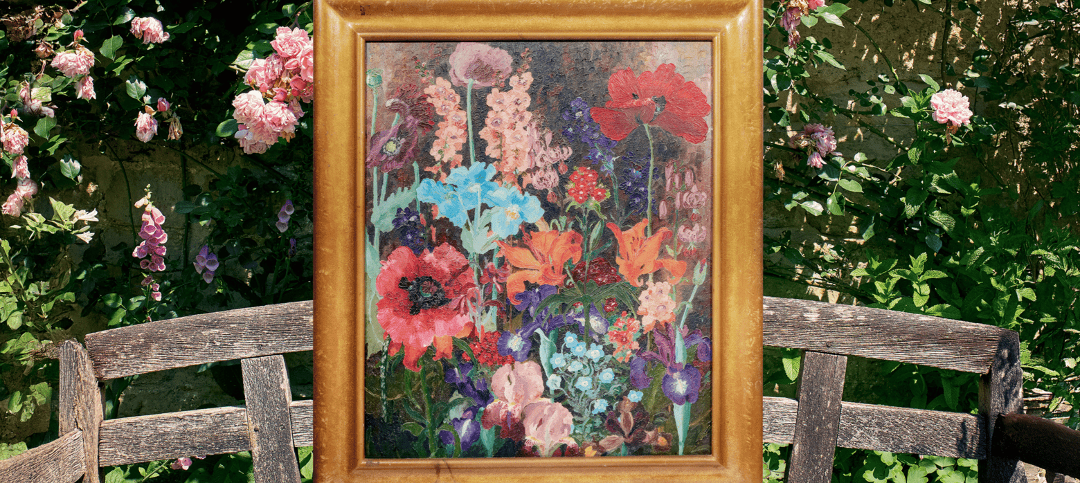 a painting of flowers in a wooden frame, sat on a wooden bench outside