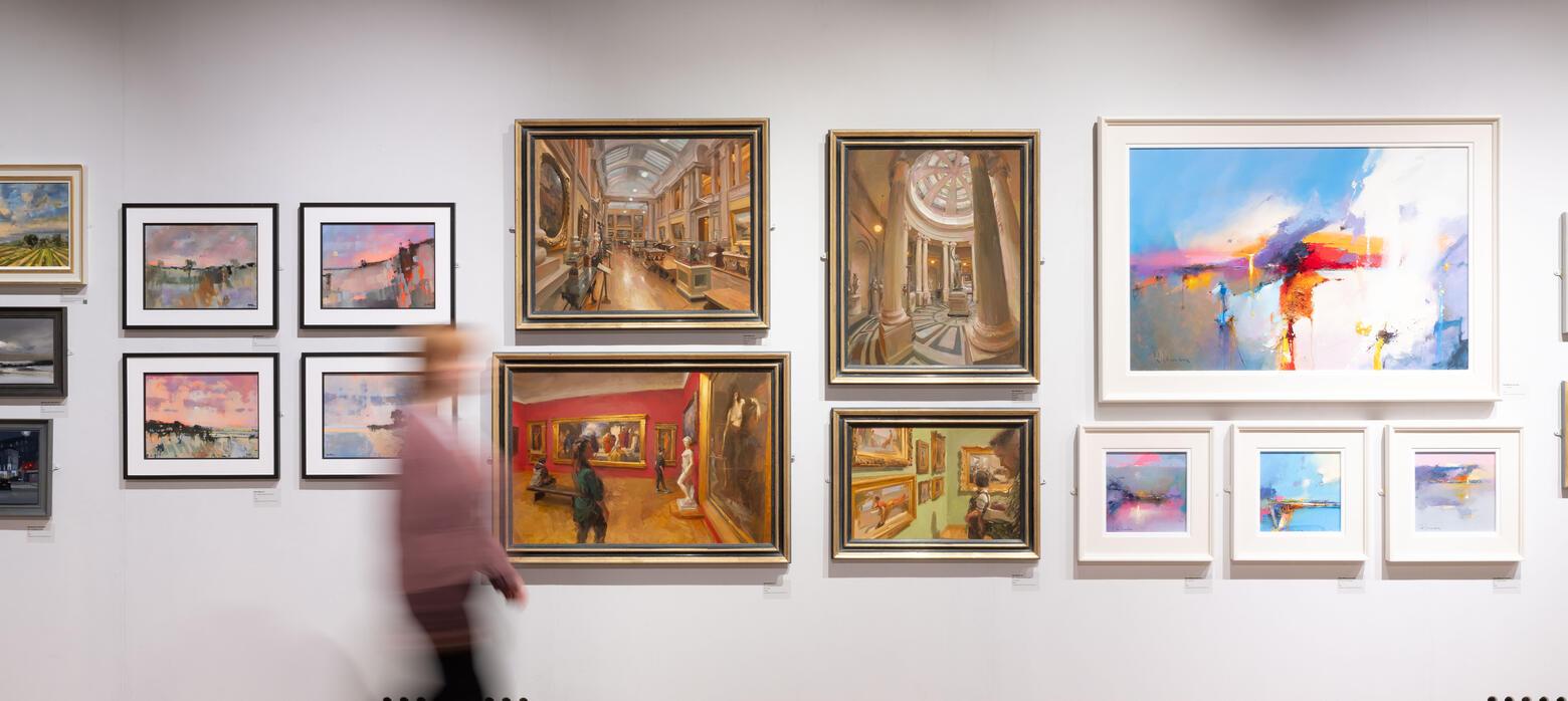 A blurry figure walks past four paintings of an art gallery
