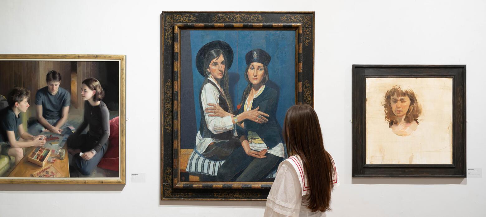 Woman looking at portrait paintings in RP Annual Exhibition