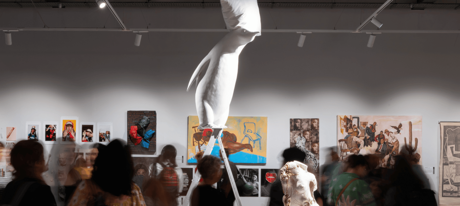 a sculpture of a penguin on a ladder with a pillow on its head