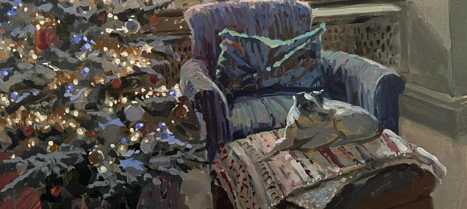 Dog on arm chair next to christmas tree