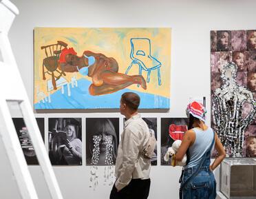 2 people looking at a wall in the west gallery