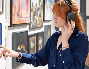 Photograph of a woman listening to a video on an iPad during the SWLA Annual Exhibition