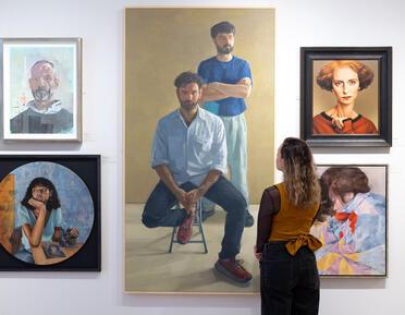 Woman looking at a collection of portraits